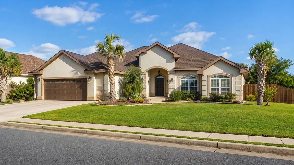 A single-family home with a clean front yard on a sunny Brownsville street in warm daylight.
